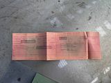 a pink ticket sitting on top of a table next to a book