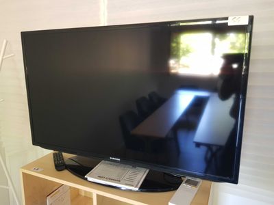 a flat screen tv sitting on top of a wooden shelf