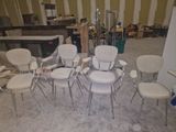 Plusieurs chaises sont disposées en cercle au milieu d'une pièce.
