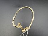un gros plan sur un collier en perles dorées orné d'un pompon