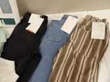 three pairs of jeans are sitting on a shelf next to a box