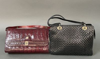two purses are lined up on a table with a gray background