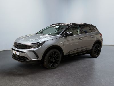 un SUV argenté garé dans une pièce au sol noir