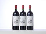 three bottles of red wine sitting on top of a table