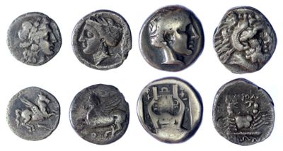 a close up of a group of ancient coins on a white surface