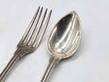 two spoons and a fork on a white surface