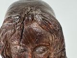 a wooden statue of a woman holding a baby
