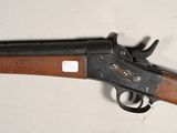 an old gun with a wooden handle on a white surface