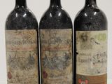 three bottles of wine are lined up on a white surface