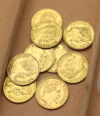 beaucoup de pièces d'or dans une boîte posée sur la table