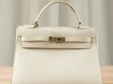 a white handbag sitting on top of a wooden table