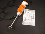 an orange and white electric drill on a black table