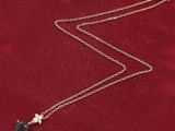 a close up of a gold necklace with a blue stone on it