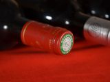 several bottles of wine are lined up on a red surface