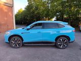 a blue suv parked in a parking lot with trees in the background