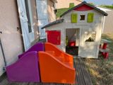 a little house with a slide and a play house in the back yard