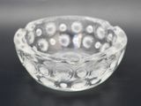 a small glass bowl on a table with a black background