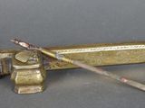 un vieux tuyau en laiton muni d'un manche en bois et d'une brosse