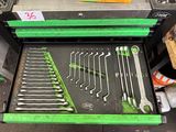 many wrenches in a green tool box on the floor