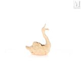 une petite statue représentant un oiseau posée sur une surface blanche