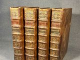 a set of four old books sitting on top of each other