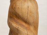 wooden sculpture of a woman ' s head on a white pedestal