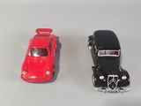 two toy cars sitting next to each other on a white surface