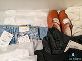 a suitcase with clothes and a pair of shoes on top of it