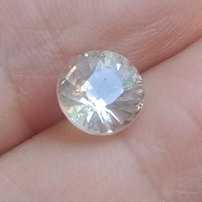 un gros plan sur la main d'une personne tenant un diamant blanc