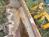 un bulldozer jaune posé par terre à côté d'un tas d'ordures