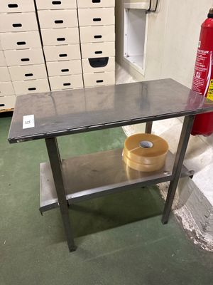 une table en métal sur laquelle est posé un bol, dans une pièce