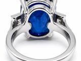 an oval blue sapphire and diamond ring on a white background