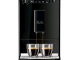 La machine est noire et contient deux tasses de café.
