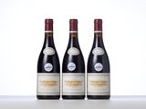 three bottles of red wine sitting on top of a table