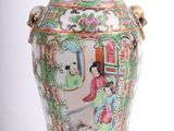 a vase with a painting on it sitting on a table