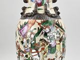 a vase with a painting on it sitting on a table