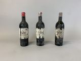 trois bouteilles de vin posées l'une à côté de l'autre sur une table