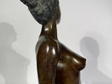 statue of a woman with a hat on her head sitting on a table