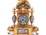 a clock that is sitting on a table with a picture on it