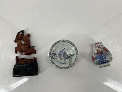 trois figurines miniatures posées sur une surface blanche