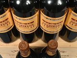 six bottles of red wine in a wooden crate on a table