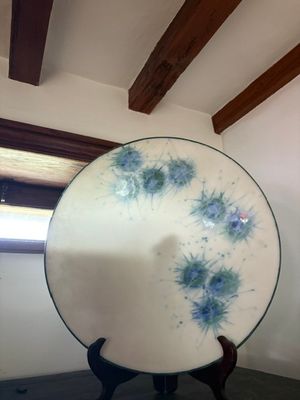 Dans une pièce, quelqu'un tient une assiette décorée de fleurs bleues.