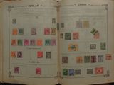 an open book with stamps on it sitting on a table
