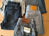 Plusieurs paires de jeans sont empilées sur une boîte en carton