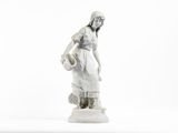 une statue blanche représentant une femme avec un panier sur la tête