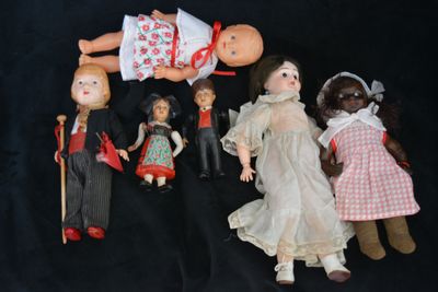 a lot of dolls that are sitting together on a black background