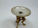 a gold plate with a bird on it on a stand