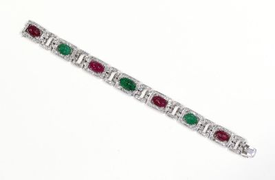 un gros plan sur un bracelet orné de pierres vertes et rouges