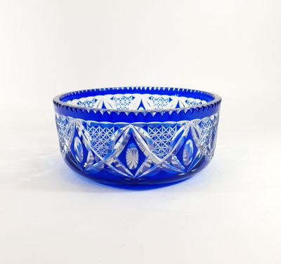 a blue glass bowl sitting on top of a white table