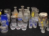bottles and glasses are lined up on a table with a black background